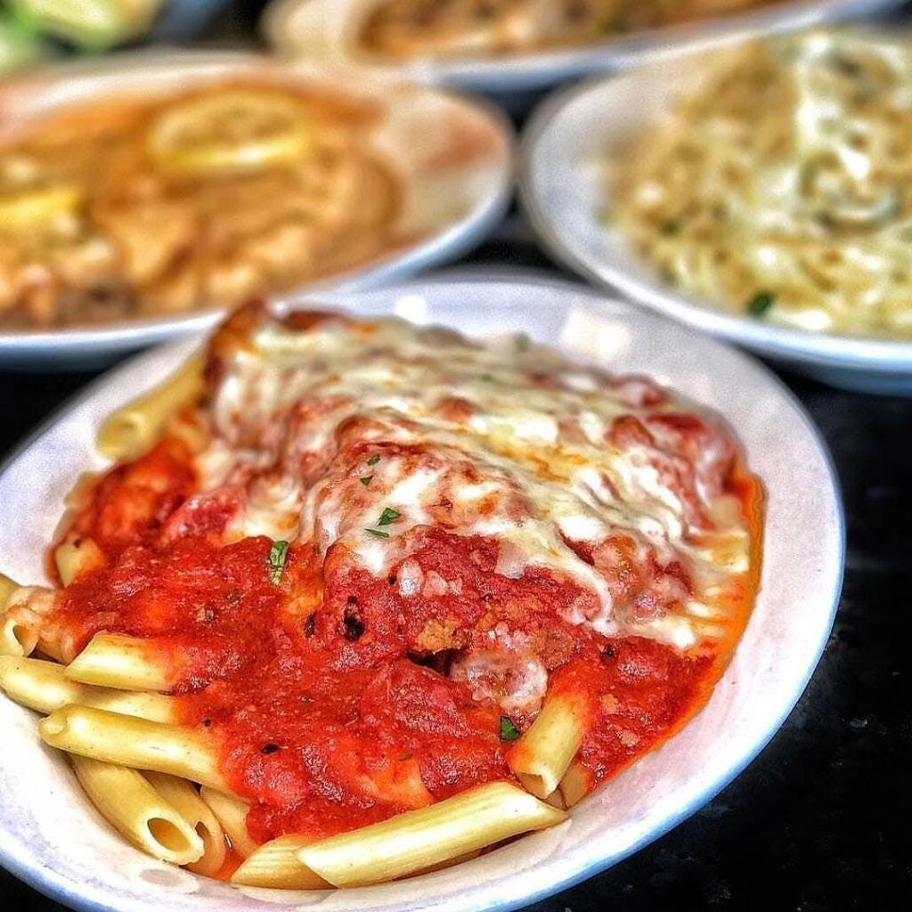 Chicken parmigiana with tomato sauce and melted mozzarella served over penne
