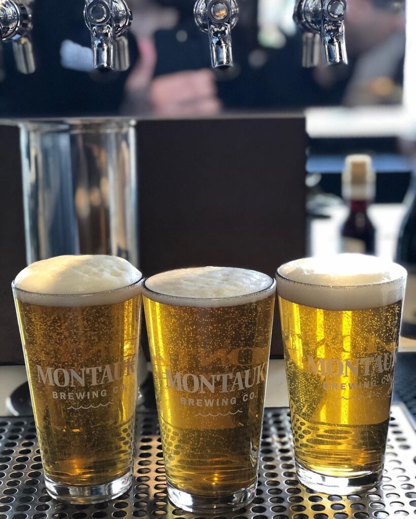 Three pints of draft beer lined up beneath the taps