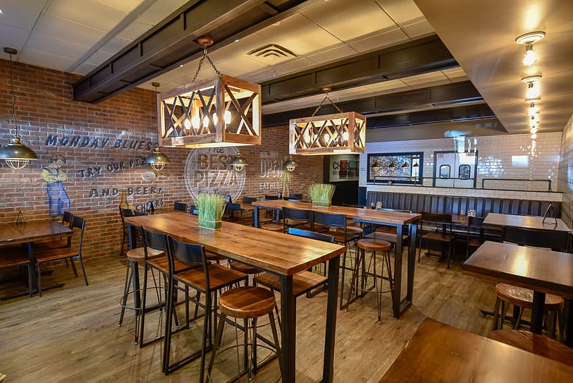 Tables and booths along the exposed brick wall of the dining room