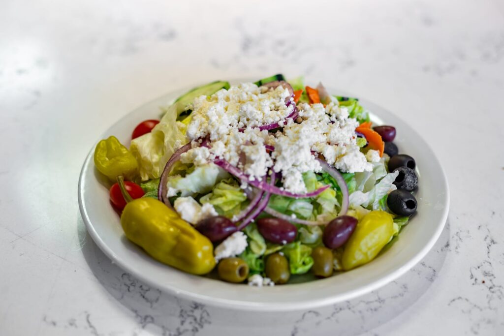 Greek salad with crumbled feta, red onion, kalamata and green olives, pepperoncini and cherry tomatoes